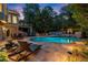 Stunning outdoor pool area with stone patio, lounge chairs, and lush greenery, perfect for relaxation at 979 Pathview Ct, Dacula, GA 30019