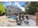A backyard view of a home with a pool and patio that includes a retaining wall and outdoor furniture at 979 Pathview Ct, Dacula, GA 30019