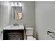 Clean half bathroom featuring a mirror, dark wood vanity, and updated fixtures at 1203 Penhurst Way, Lawrenceville, GA 30043