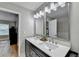 Bright bathroom features double sinks, a quartz countertop, stylish mirrors, and a tiled shower at 1203 Penhurst Way, Lawrenceville, GA 30043