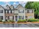 Inviting townhome featuring a well-maintained lawn, blue door, and symmetrical black shutters at 1203 Penhurst Way, Lawrenceville, GA 30043
