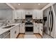 Charming kitchen featuring stainless steel appliances, modern countertops, and white cabinets at 1203 Penhurst Way, Lawrenceville, GA 30043