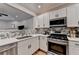 Well-lit kitchen featuring stainless steel appliances, white cabinets, and modern backsplash at 1203 Penhurst Way, Lawrenceville, GA 30043