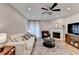 Comfortable living room featuring a fireplace, ceiling fan, and abundant natural light at 1203 Penhurst Way, Lawrenceville, GA 30043