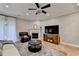 Relaxing living room featuring a fireplace, ceiling fan, and large-screen television at 1203 Penhurst Way, Lawrenceville, GA 30043