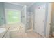 Bathroom featuring soaking tub with jets, shower, and frosted window at 155 Redspire Ln, Fayetteville, GA 30215