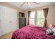 This well-lit bedroom offers a spacious closet and backyard views through bright windows at 155 Redspire Ln, Fayetteville, GA 30215