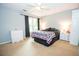 Bright and airy bedroom features a ceiling fan, dark curtains and plush carpeting for added comfort at 155 Redspire Ln, Fayetteville, GA 30215
