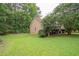 Side view of house with well-maintained lawn, trimmed shrubs and mature trees, adding to the property's appeal at 155 Redspire Ln, Fayetteville, GA 30215