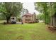 Back exterior view of house showing wooden deck, garage, lawn, mature trees, and a camper at 155 Redspire Ln, Fayetteville, GA 30215