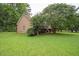 Side view of the home showcasing its lush lawn and mature trees at 155 Redspire Ln, Fayetteville, GA 30215