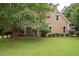 Inviting home exterior featuring a lush green lawn and mature trees offering shade and beauty at 155 Redspire Ln, Fayetteville, GA 30215