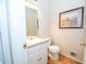 This practical half bathroom features tile floors, a framed print and a white vanity at 155 Redspire Ln, Fayetteville, GA 30215