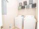 This cozy laundry room includes a white washer, dryer, and storage shelves to maximize space and organization at 155 Redspire Ln, Fayetteville, GA 30215