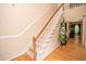 Elegant staircase with white banisters and hardwood floors adds a touch of sophistication to the home at 155 Redspire Ln, Fayetteville, GA 30215