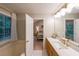Bathroom with modern vanity, tub, a large window, and access to the primary bedroom at 3318 Freedom Lndg, Kennesaw, GA 30144