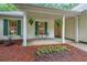 Inviting front porch featuring hanging ferns, a small table with chairs and decorative landscaping at 3318 Freedom Lndg, Kennesaw, GA 30144
