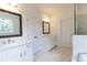 Bright bathroom with double sink, marble tile floor, and glass shower featuring white cabinets and a modern design at 709 Dodd Ln # 165, Buford, GA 30518