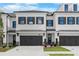 Charming townhome showcases a light brick facade, black trim, garage, and manicured lawn at 709 Dodd Ln # 165, Buford, GA 30518