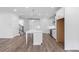 Open-concept kitchen showcases a center island, stainless steel appliances, and transitions into the living area at 709 Dodd Ln # 165, Buford, GA 30518