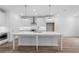 Modern kitchen with an island, white cabinetry, and stainless steel range hood at 709 Dodd Ln # 165, Buford, GA 30518