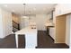 Bright kitchen features an island, stainless steel appliances, white cabinets and hardwood floors at 709 Dodd Ln # 165, Buford, GA 30518