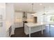 Modern kitchen featuring white cabinets, a stainless steel range hood, and an island with a sink at 709 Dodd Ln # 165, Buford, GA 30518