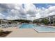 Community pool with lounge chairs, sun deck, and inviting blue water under a cloudy sky at 709 Dodd Ln # 165, Buford, GA 30518