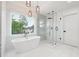 Modern bathroom with glass shower, a soaking tub, neutral tile, and modern fixtures at 5535 Buck Hollow Dr, Alpharetta, GA 30005