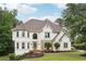 Elegant two-story home featuring a stone accent, manicured lawn, and a welcoming entrance at 5535 Buck Hollow Dr, Alpharetta, GA 30005