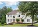 Elegant two-story home featuring stone accents, a manicured lawn, and lush landscaping at 5535 Buck Hollow Dr, Alpharetta, GA 30005