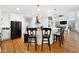 Bright kitchen boasts white cabinets, stainless steel appliances, kitchen island, and hardwood floors at 5535 Buck Hollow Dr, Alpharetta, GA 30005