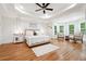 Spacious main bedroom with hardwood floors, tray ceilings, a ceiling fan, and large windows at 5535 Buck Hollow Dr, Alpharetta, GA 30005