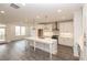 Modern kitchen featuring white cabinets, a large island, stainless steel appliances and stylish pendant lighting at 706 Dodd Ln # 157, Buford, GA 30518