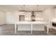 Bright kitchen boasts a large island, stainless steel appliances, white cabinets and pendant lighting at 706 Dodd Ln # 157, Buford, GA 30518