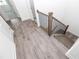 Hallway with wood-style flooring and a modern staircase featuring a black metal railing at 706 Dodd Ln # 157, Buford, GA 30518