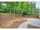 Landscaped backyard featuring a stone paver patio and privacy fence, ideal for outdoor living at 728 Lorimore Pass, Canton, GA 30115