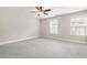 Bright bedroom features neutral walls, plush gray carpet, a ceiling fan and two windows offering natural light at 728 Lorimore Pass, Canton, GA 30115