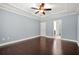 Spacious bedroom featuring a ceiling fan, tray ceiling, and beautiful hardwood floors at 728 Lorimore Pass, Canton, GA 30115