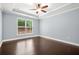 Serene bedroom with tray ceiling, hardwood floors, and a window providing natural light and outdoor views at 728 Lorimore Pass, Canton, GA 30115
