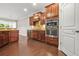 Beautiful kitchen featuring dark wood cabinets, stainless steel oven, granite countertops, and hardwood floors at 728 Lorimore Pass, Canton, GA 30115