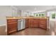 Kitchen with dark wood cabinets, stainless steel dishwasher, hardwood floors, and tile backsplash at 728 Lorimore Pass, Canton, GA 30115