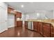 Kitchen with dark wood cabinets, stainless steel dishwasher, hardwood floors, and tile backsplash at 728 Lorimore Pass, Canton, GA 30115