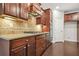 Well-equipped kitchen with dark wood cabinetry, granite countertops, tiled backsplash, and stainless steel appliances at 728 Lorimore Pass, Canton, GA 30115