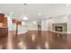 Open concept living room and kitchen with stone fireplace and hardwood floors, filled with natural light at 728 Lorimore Pass, Canton, GA 30115