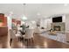 Staged living room with fireplace, kitchen view, hardwood floors, modern furniture, creating a cozy atmosphere at 728 Lorimore Pass, Canton, GA 30115