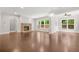 Bright living room featuring a stone fireplace, hardwood floors, neutral walls, and multiple windows overlooking the yard at 728 Lorimore Pass, Canton, GA 30115