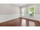 Bright, open room with hardwood floors, decorative wainscotting, and natural light from two windows at 728 Lorimore Pass, Canton, GA 30115