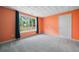 Bright bedroom with orange walls, window, white door, and light gray carpeting at 1440 Boundary Blvd, Suwanee, GA 30024
