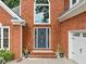 Close-up of a brick home with a decorative front door and well-maintained landscaping at 1440 Boundary Blvd, Suwanee, GA 30024